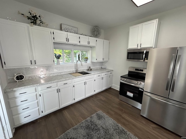 1000 Hartford St, Lafayette, IN 47900 - kitchen featuring stainless steel appliances, a sink, white cabinets, dark wood-type flooring, and decorative backsplash