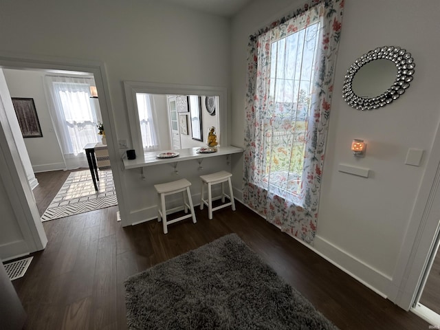 1000 Hartford St, Lafayette, IN 47900 - kitchen featuring dark wood-style flooring, a breakfast bar area, baseboards, and light countertops