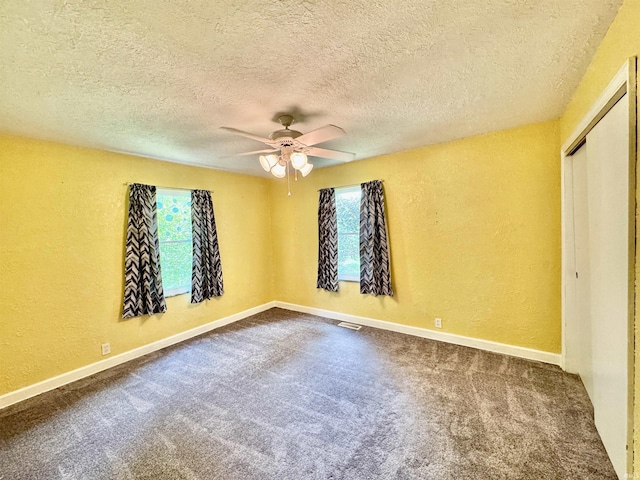 2424 S Webster St, Kokomo, IN 46902 - empty room featuring a textured wall, ceiling fan, dark colored carpet, a textured ceiling, and baseboards