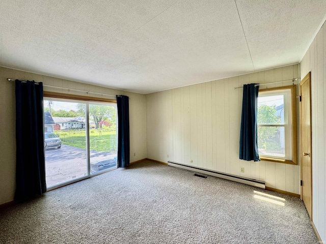 2424 S Webster St, Kokomo, IN 46902 - carpeted empty room with a baseboard heating unit, healthy amount of natural light, a textured ceiling, and baseboards