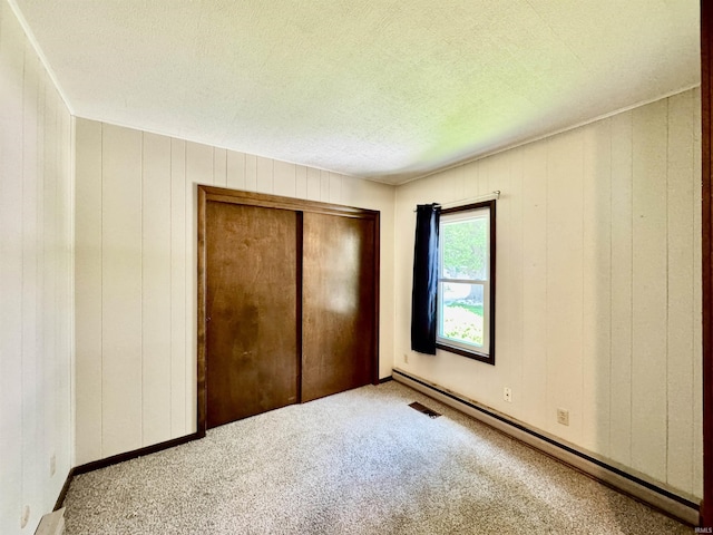 2424 S Webster St, Kokomo, IN 46902 - unfurnished bedroom featuring a baseboard heating unit, a closet, carpet flooring, and a textured ceiling