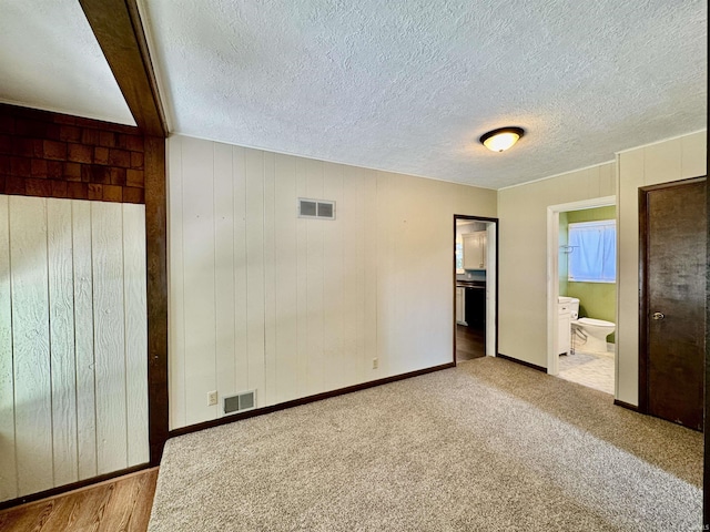 2424 S Webster St, Kokomo, IN 46902 - unfurnished bedroom with ensuite bath, baseboards, a textured ceiling, and carpet floors