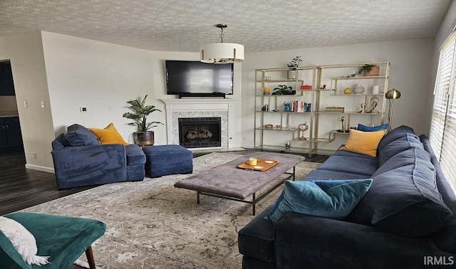 1101 E Boone St, Frankfort, IN 46041 - living area with wood finished floors, a fireplace, a textured ceiling, and baseboards