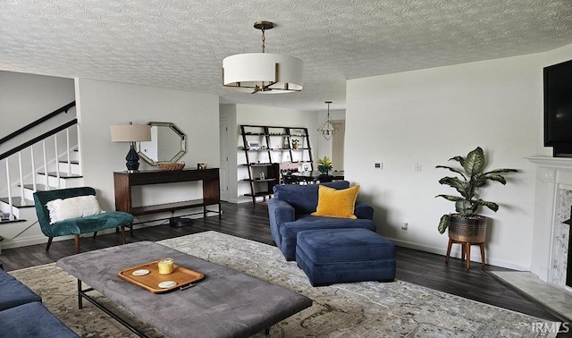 1101 E Boone St, Frankfort, IN 46041 - living room featuring wood finished floors, stairway, baseboards, a high end fireplace, and a textured ceiling