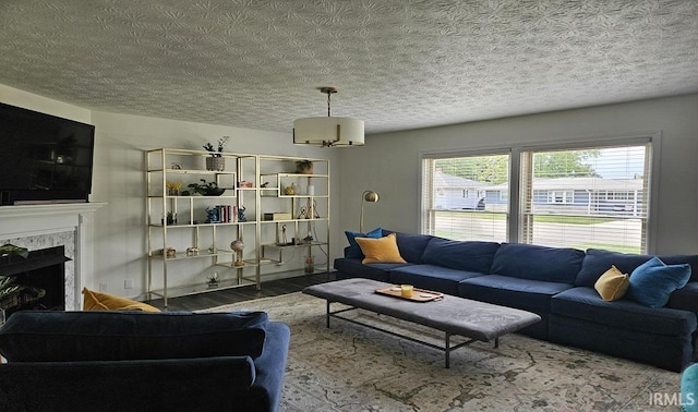 1101 E Boone St, Frankfort, IN 46041 - living room featuring wood finished floors, a fireplace, a chandelier, and a textured ceiling