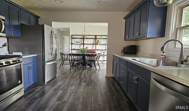 1101 E Boone St, Frankfort, IN 46041 - kitchen featuring stainless steel appliances, a sink, light countertops, a textured ceiling, and dark wood-style floors