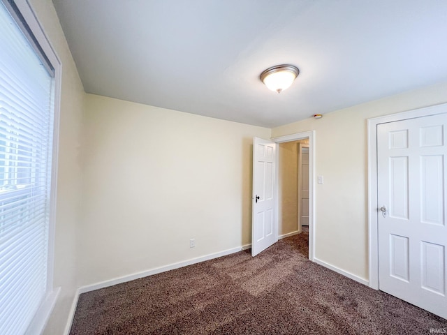 158 Simpson Ave, Elkhart, IN 46516 - unfurnished bedroom featuring dark carpet and baseboards