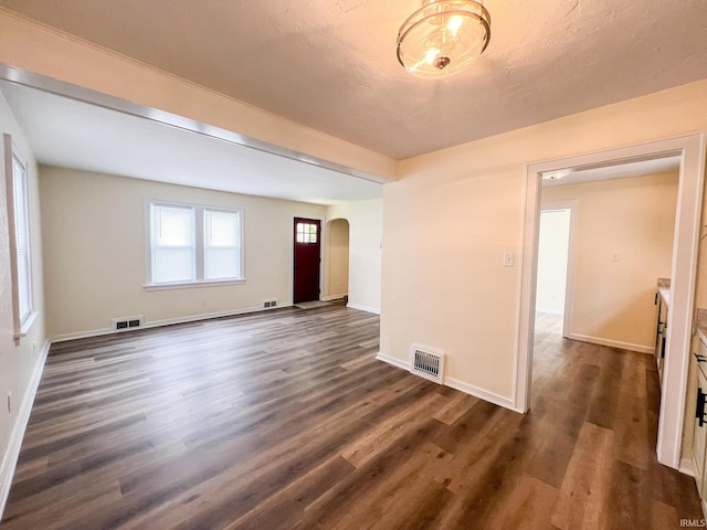 158 Simpson Ave, Elkhart, IN 46516 - spare room featuring arched walkways, dark wood-type flooring, and baseboards
