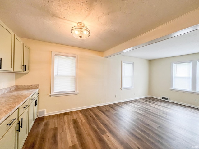 158 Simpson Ave, Elkhart, IN 46516 - unfurnished dining area featuring dark wood-style flooring, baseboards, and a textured ceiling