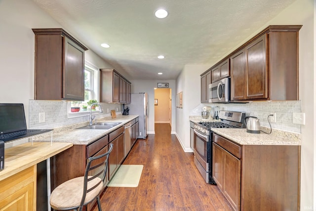 4774 W Hidden Meadow Dr, Bloomington, IN 47404 - kitchen featuring appliances with stainless steel finishes, a sink, tasteful backsplash, dark wood finished floors, and recessed lighting