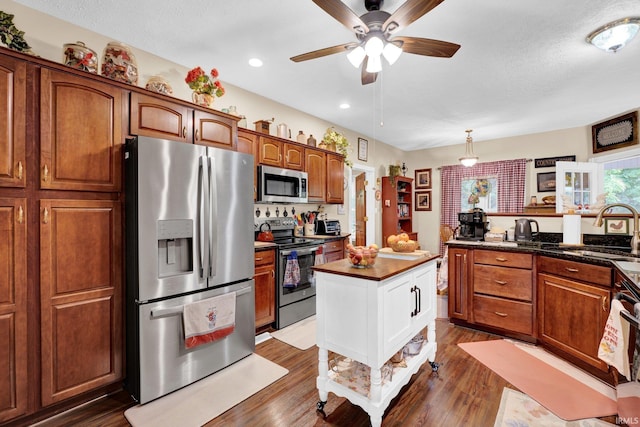 91 Smiths Rd, Mitchell, IN 47446 - kitchen featuring stainless steel appliances, a sink, dark countertops, a ceiling fan, and wood finished floors