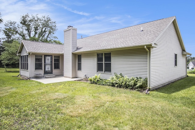 18086 Courtland Dr, South Bend, IN 46637 - back of house featuring a chimney, a patio, a shingled roof, and a yard