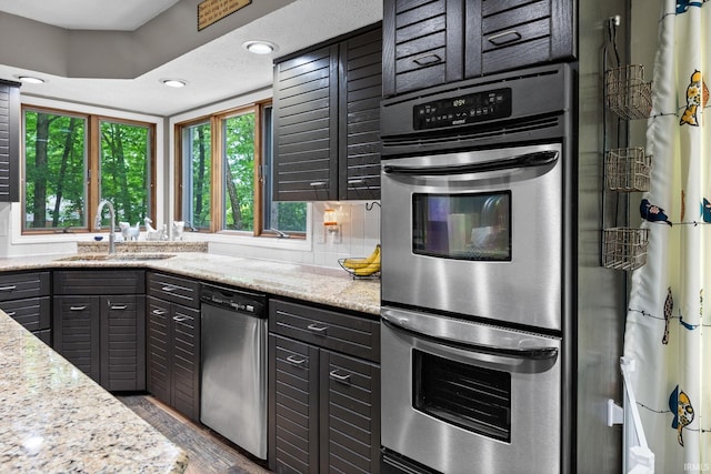 1320 Castle Dr, Lafayette, IN 47905 - kitchen featuring stainless steel appliances, a sink, wood finished floors, light stone counters, and recessed lighting