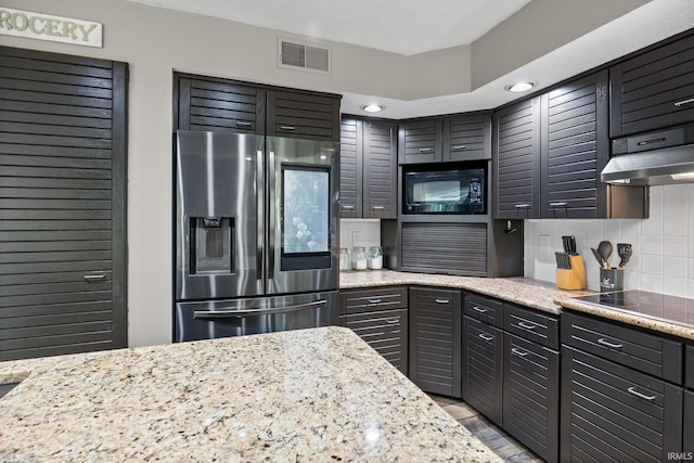 1320 Castle Dr, Lafayette, IN 47905 - kitchen featuring black appliances, under cabinet range hood, light stone countertops, decorative backsplash, and light wood-type flooring