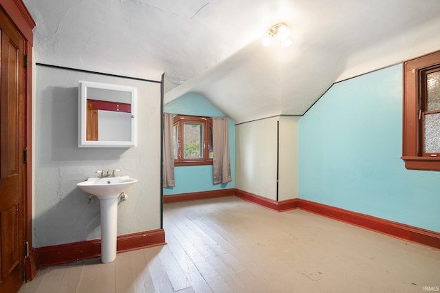 706 Park Ave, South Bend, IN 46616 - bathroom featuring vaulted ceiling, wood-type flooring, baseboards, and a sink