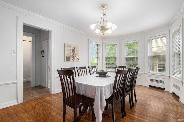 706 Park Ave, South Bend, IN 46616 - dining room featuring a chandelier, crown molding, wood-type flooring, radiator, and baseboards