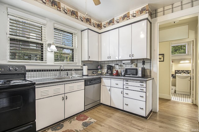 706 Park Ave, South Bend, IN 46616 - kitchen featuring stainless steel appliances, a sink, dark countertops, white cabinetry, and light wood-style flooring