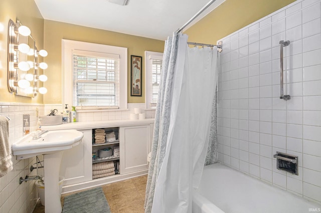 706 Park Ave, South Bend, IN 46616 - bathroom featuring shower / bath combo, tile patterned flooring, wainscoting, tile walls, and a sink