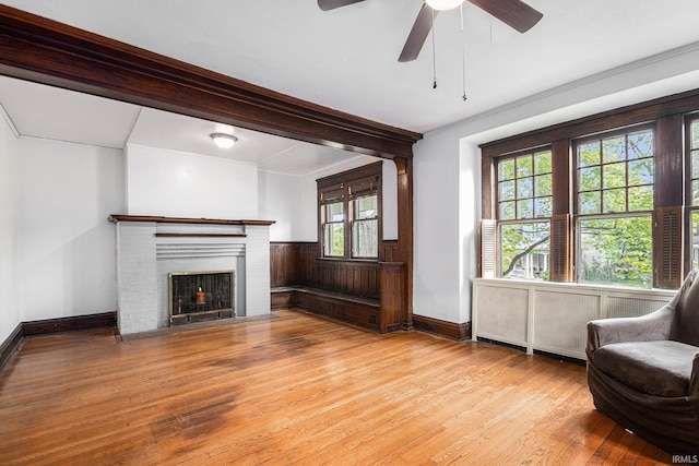 706 Park Ave, South Bend, IN 46616 - living area featuring wood-type flooring, a ceiling fan, baseboards, a brick fireplace, and radiator