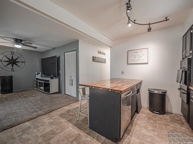11219 Denzer Rd, Evansville, IN 47712 - kitchen with butcher block countertops, a kitchen breakfast bar, ceiling fan, oven, and light carpet