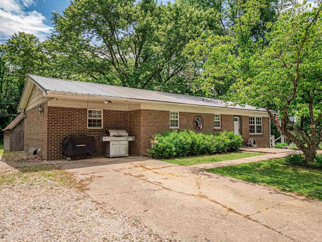 11219 Denzer Rd, Evansville, IN 47712 - view of front facade featuring brick siding, concrete driveway, metal roof, and an attached carport