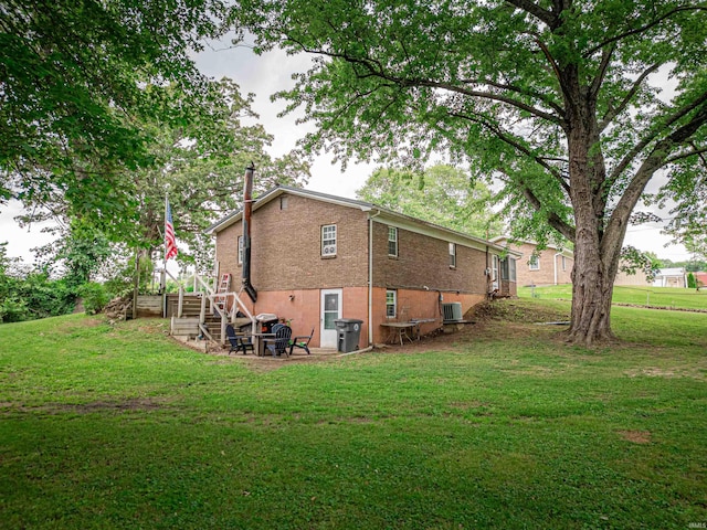 11219 Denzer Rd, Evansville, IN 47712 - back of property with stairs, a lawn, cooling unit, and brick siding