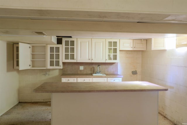 802 Hasenour Ave, Jasper, IN 47546 - kitchen featuring a sink, open shelves, a kitchen island, glass insert cabinets, and light countertops