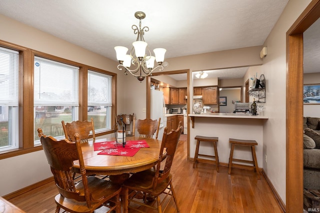 300 S Heritage Dr, Delphi, IN 46923 - dining room with a chandelier, light wood-type flooring, and baseboards