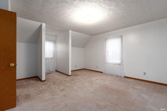 300 S Heritage Dr, Delphi, IN 46923 - additional living space with carpet flooring, vaulted ceiling, a textured ceiling, and baseboards