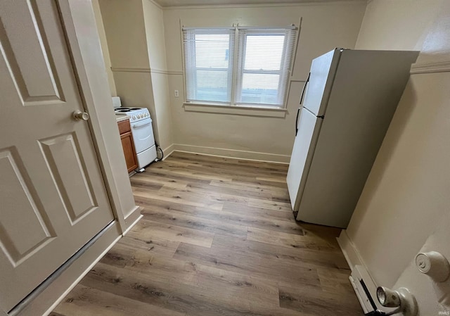 2130 Broadway, Fort Wayne, IN 46802 - kitchen featuring white appliances, light wood-type flooring, brown cabinetry, and baseboards