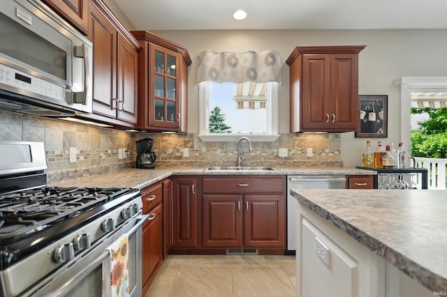 12815 Chaplin Ct, Fort Wayne, IN 46845 - kitchen with stainless steel appliances, a sink, decorative backsplash, glass insert cabinets, and recessed lighting
