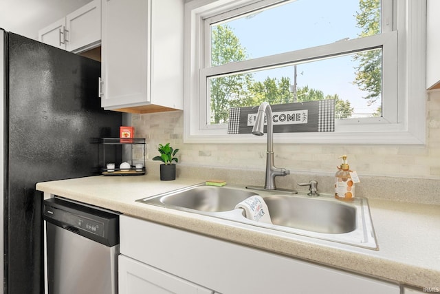 2604 Bellevue Dr, Fort Wayne, IN 46825 - kitchen with dishwasher, a sink, freestanding refrigerator, white cabinets, and decorative backsplash