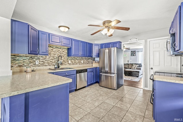 542 E Michigan St, New Carlisle, IN 46552 - kitchen featuring appliances with stainless steel finishes, a sink, blue cabinetry, and a ceiling fan
