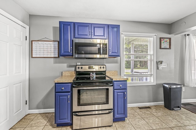 542 E Michigan St, New Carlisle, IN 46552 - kitchen featuring appliances with stainless steel finishes, blue cabinetry, light countertops, and baseboards