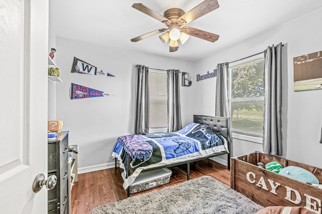 542 E Michigan St, New Carlisle, IN 46552 - bedroom with baseboards, wood finished floors, and a ceiling fan