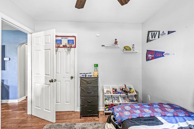 542 E Michigan St, New Carlisle, IN 46552 - bedroom with wood finished floors, arched walkways, ceiling fan, and baseboards