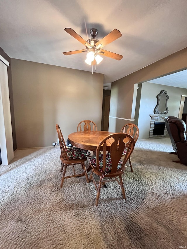 503 Laura Ln, Sweetser, IN 46987 - carpeted dining area featuring a ceiling fan and a fireplace