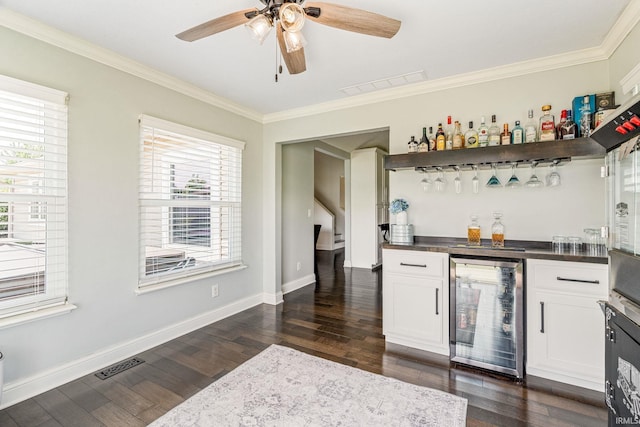 210 Meadows Dr, Greentown, IN 46936 - indoor dry bar featuring beverage cooler, ornamental molding, dark wood-type flooring, a ceiling fan, and baseboards