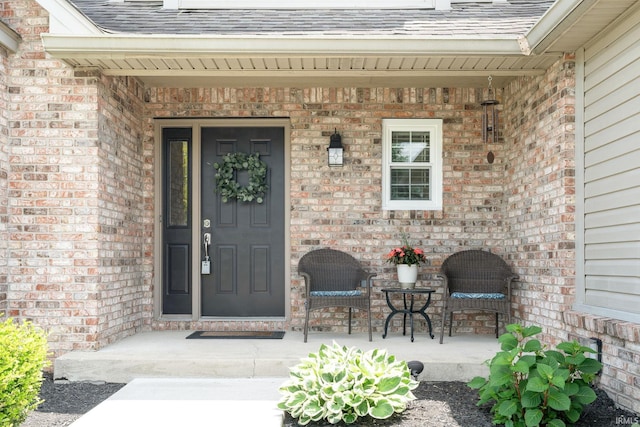 210 Meadows Dr, Greentown, IN 46936 - entrance to property with brick siding, a shingled roof, and covered porch
