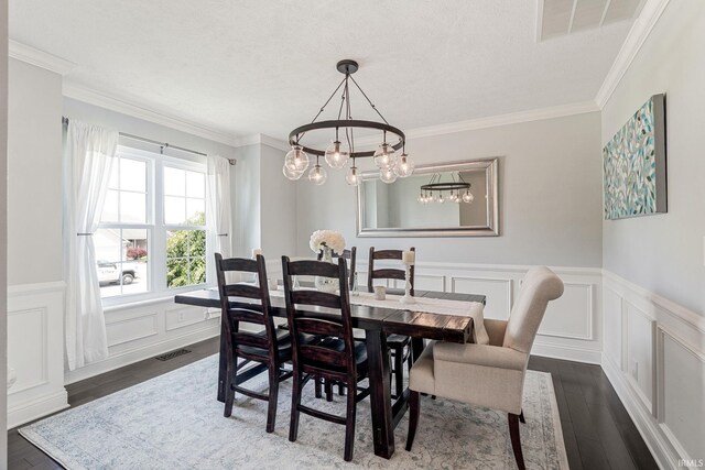 210 Meadows Dr, Greentown, IN 46936 - dining area featuring dark wood-style floors, a decorative wall, a wainscoted wall, a chandelier, and crown molding