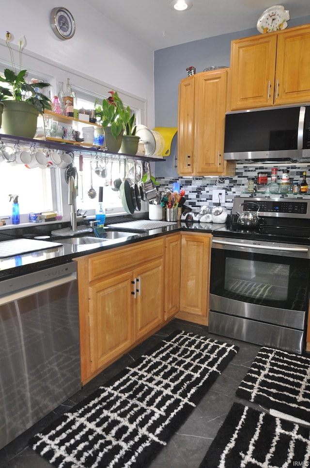 1502 S College Ave, Bloomington, IN 47403 - kitchen featuring stainless steel appliances, a sink, backsplash, and dark countertops