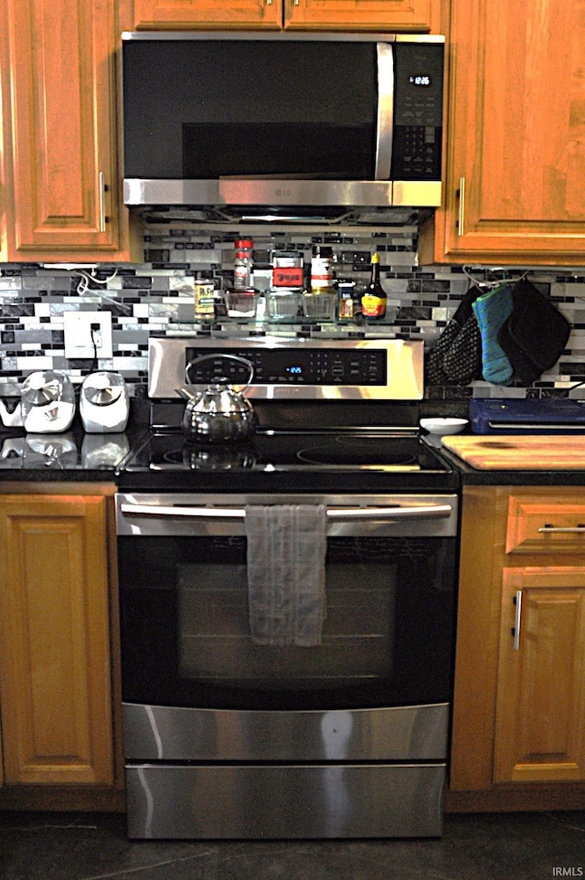 1502 S College Ave, Bloomington, IN 47403 - kitchen with stainless steel appliances, tasteful backsplash, and dark countertops