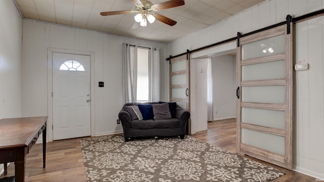3215 Forest Ave, Evansville, IN 47712 - foyer with a barn door, ceiling fan, light wood-type flooring, and baseboards