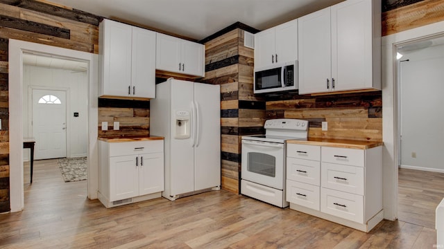 3215 Forest Ave, Evansville, IN 47712 - kitchen with white appliances, wooden walls, light wood finished floors, white cabinets, and backsplash