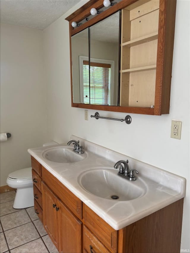 999 Inderrieden Rd, Chandler, IN 47610 - bathroom with double vanity, toilet, tile patterned flooring, and a textured ceiling