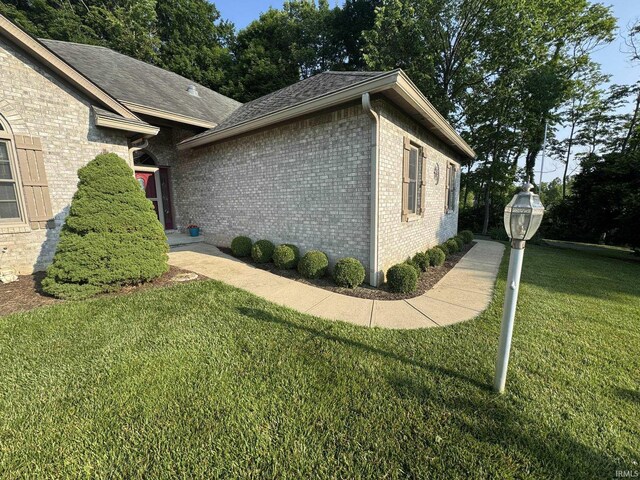 5003 N Chatham Dr, Bloomington, IN 47404 - view of home's exterior featuring brick siding, a lawn, and roof with shingles