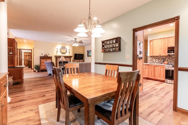 5003 N Chatham Dr, Bloomington, IN 47404 - dining area with ceiling fan, light wood-style flooring, a fireplace, a chandelier, and recessed lighting