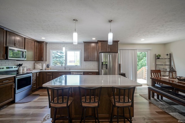 60 Elder Ct, Lafayette, IN 47905 - kitchen with appliances with stainless steel finishes, a textured ceiling, decorative backsplash, light countertops, and dark wood finished floors