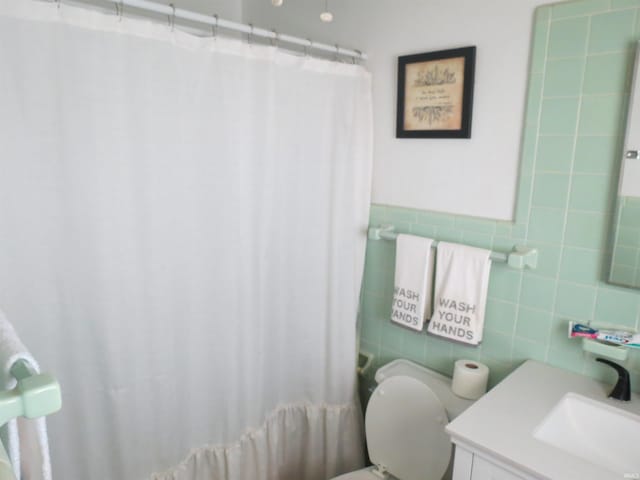 801 E Sycamore St, Petersburg, IN 47567 - bathroom with tile walls, vanity, toilet, and curtained shower