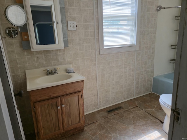 150 W Lake St, Laketon, IN 46943 - bathroom with vanity, toilet, washtub / shower combination, and stone finish floors